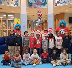  Pre-K students and their teachers smile for a photo while dressed as the Cat in the Hat.