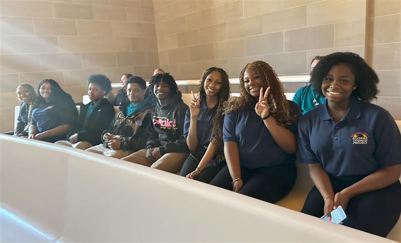 GCP scholars smiling sitting on a pew
