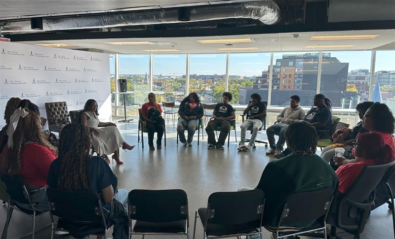 Students seated in a circle listening to a speaker at the Ralph J. Bunch International Affairs Center