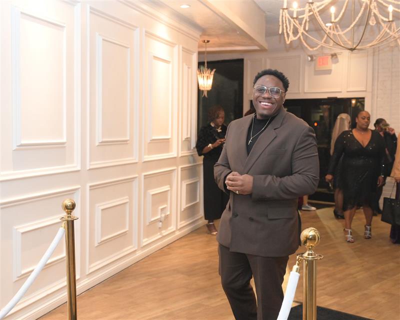 Man smiling on black carpet entrance