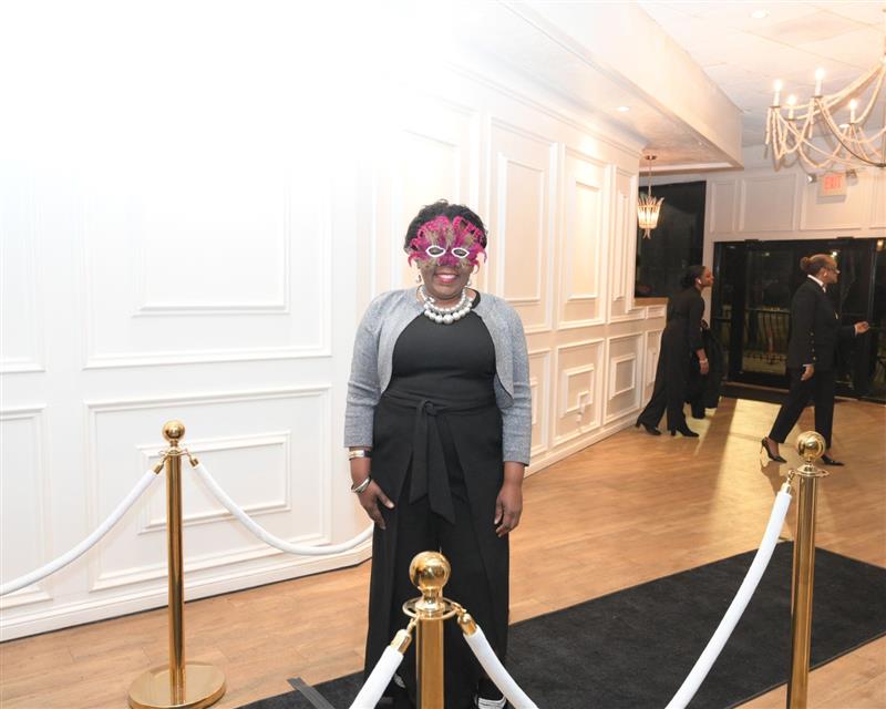 Smiling woman in black formal on black carpet