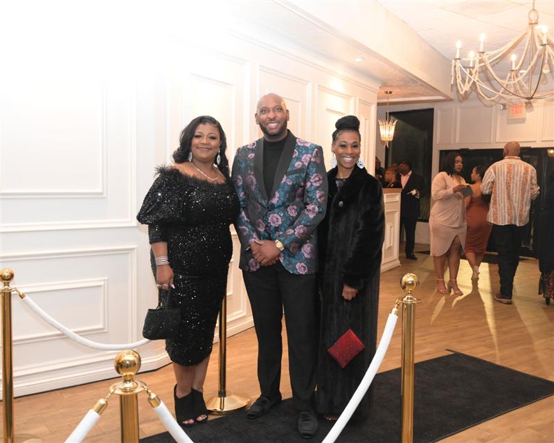 Smiling trio on black carpet entrance